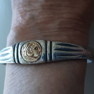 Silver bangle bracelet with gold coin replica.